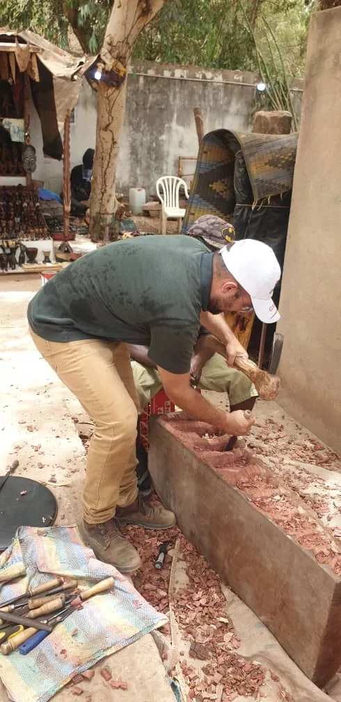 Matteo trying wood carving with an artisan